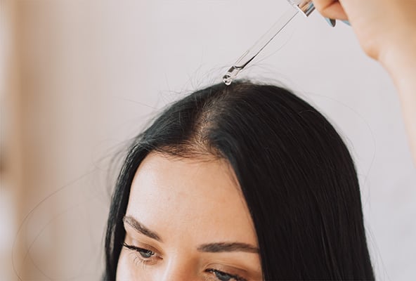 woman applying scalp drops